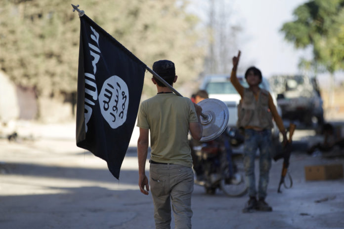 A rebel fighter takes away a flag that belonged to Islamic State militants in Akhtarin village, after rebel fighters advanced in the area, in northern Aleppo Governorate